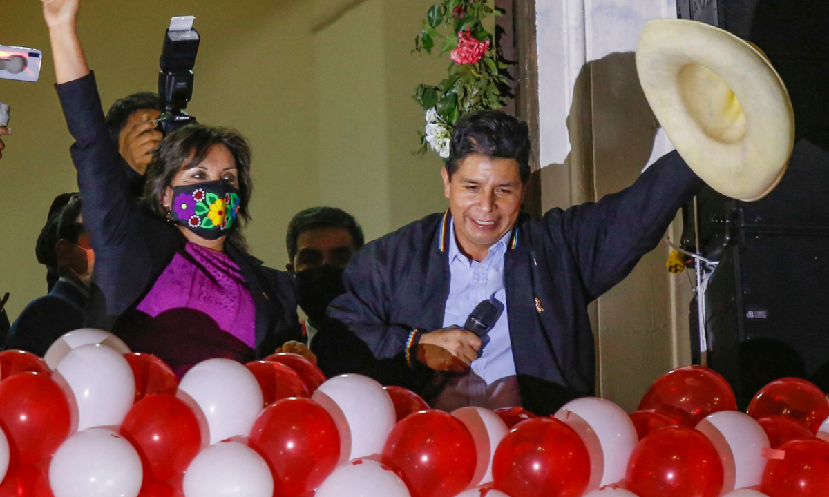 Zvolený peruánský prezident Pedro Castillo (R) a viceprezidentka Dina Boluarte zdraví své příznivce během oslavy v ústředí Peru Libre po slavnostním předání pověřovacích listin pro období 2021–2026 v Limě dne 23. července 2021