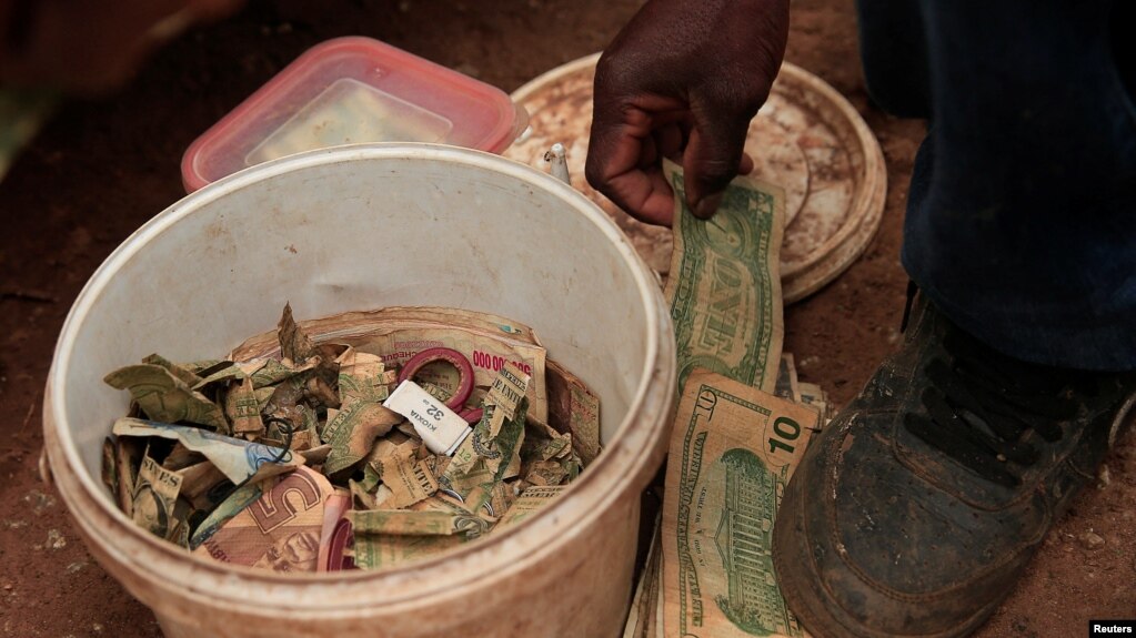 Cuthbert Gudza, 33 let, pouliční obchodník s penězi opravuje bankovky před nákupním centrem ve čtvrti Kuwadzana, Harare, Zimbabwe, ledna. 18, 2023